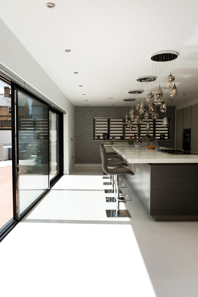 На фото: большая отдельная, прямая кухня в современном стиле с полуостровом и белым полом