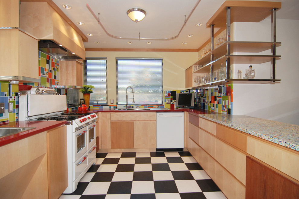 Foto på ett mellanstort funkis kök, med en dubbel diskho, släta luckor, skåp i ljust trä, bänkskiva i återvunnet glas, blått stänkskydd, stänkskydd i cementkakel, vita vitvaror, linoleumgolv och en halv köksö