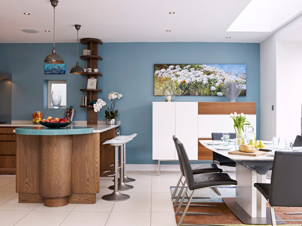 Medium sized contemporary kitchen/diner in London with flat-panel cabinets, medium wood cabinets, recycled glass countertops, stainless steel appliances and a breakfast bar.