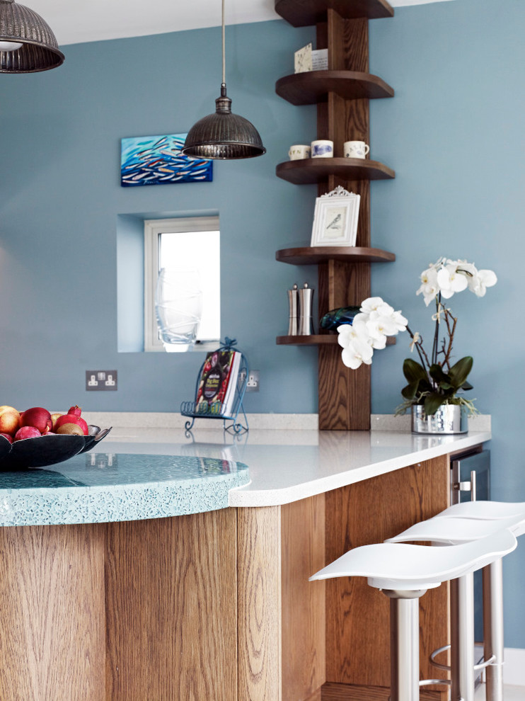 Foto di una cucina abitabile contemporanea di medie dimensioni con ante lisce, ante in legno scuro, top in vetro riciclato, elettrodomestici in acciaio inossidabile e penisola