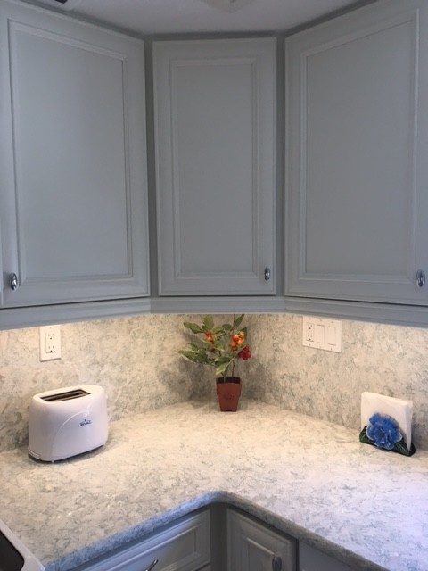 Kitchen - mid-sized coastal kitchen idea in Miami with recessed-panel cabinets, white cabinets, quartz countertops, stone slab backsplash and white appliances