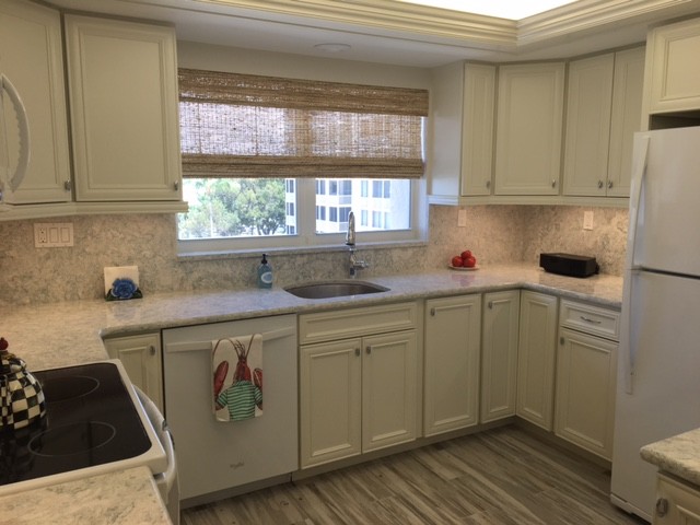 Example of a mid-sized beach style kitchen design in Miami with recessed-panel cabinets, white cabinets, stone slab backsplash, white appliances and quartz countertops