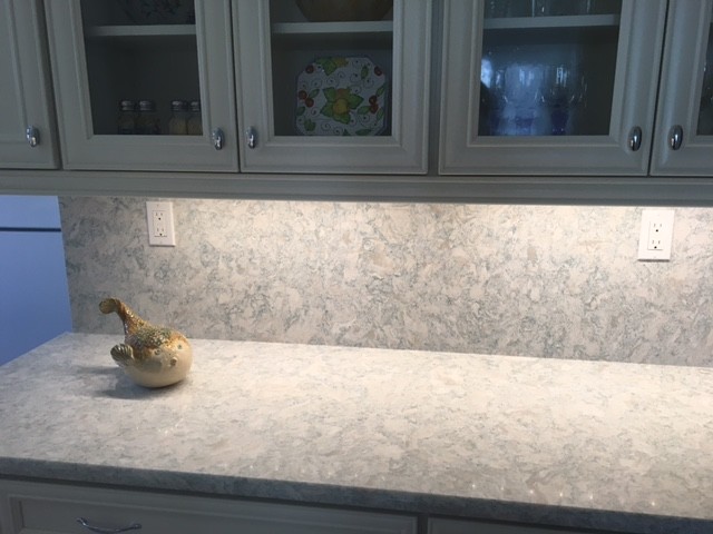 Kitchen - mid-sized coastal kitchen idea in Miami with white cabinets, quartz countertops, recessed-panel cabinets, stone slab backsplash and white appliances