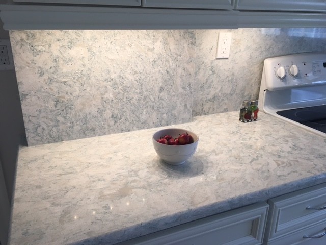 Inspiration for a mid-sized coastal kitchen remodel in Miami with recessed-panel cabinets, white cabinets, quartz countertops, stone slab backsplash and white appliances