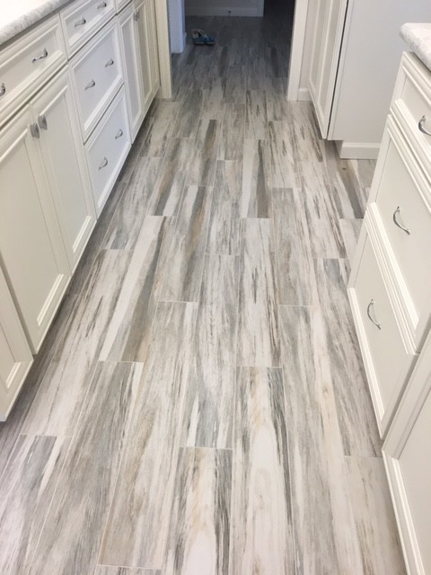 Inspiration for a mid-sized coastal porcelain tile kitchen remodel in Miami with recessed-panel cabinets, white cabinets, white appliances, an undermount sink, quartz countertops and stone slab backsplash