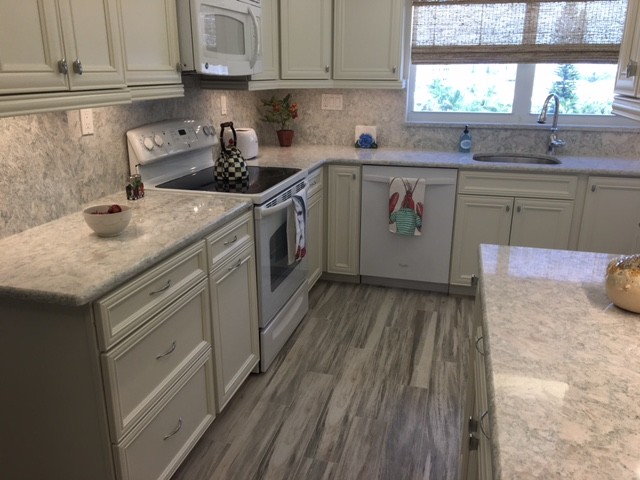Kitchen - mid-sized coastal porcelain tile kitchen idea in Miami with recessed-panel cabinets, white cabinets, stone slab backsplash, white appliances, an undermount sink and quartz countertops