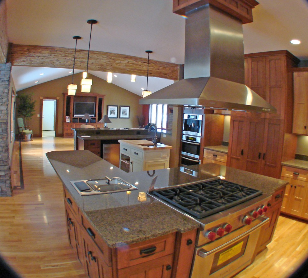 Large traditional u-shaped open plan kitchen in Minneapolis with a double-bowl sink, shaker cabinets, medium wood cabinets, granite worktops, grey splashback, stainless steel appliances, medium hardwood flooring and multiple islands.