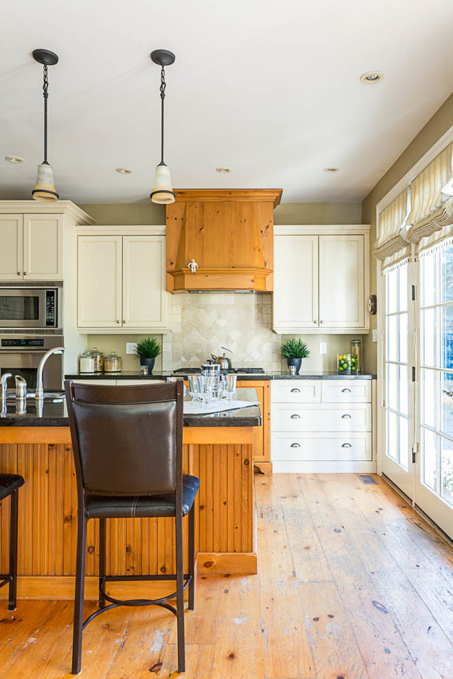 Inspiration for a mid-sized cottage galley medium tone wood floor enclosed kitchen remodel in Toronto with an undermount sink, shaker cabinets, medium tone wood cabinets, granite countertops, multicolored backsplash, ceramic backsplash, stainless steel appliances and an island