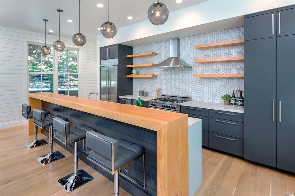 Mittelgroße Moderne Küche mit flächenbündigen Schrankfronten, Küchenrückwand in Weiß, Küchengeräten aus Edelstahl, Kücheninsel, hellem Holzboden und beigem Boden in San Francisco
