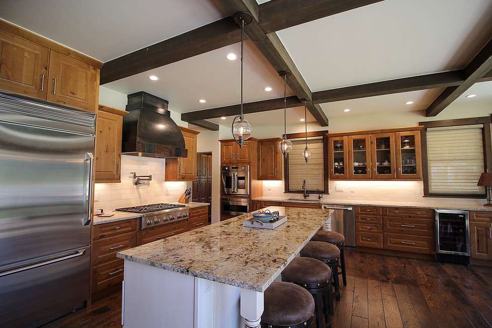 Design ideas for a large traditional galley kitchen/diner in Albuquerque with a submerged sink, medium wood cabinets, granite worktops, white splashback, stone tiled splashback, stainless steel appliances, medium hardwood flooring, an island, brown floors and beige worktops.