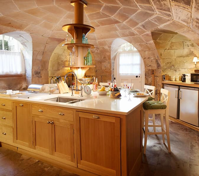 Aménagement d'une cuisine linéaire et encastrable moderne en bois clair avec un évier encastré, un plan de travail en quartz, îlot et un plan de travail beige.