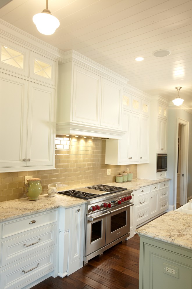 Klassisk inredning av ett kök, med en rustik diskho, luckor med profilerade fronter, vita skåp, granitbänkskiva, beige stänkskydd, stänkskydd i glaskakel och integrerade vitvaror