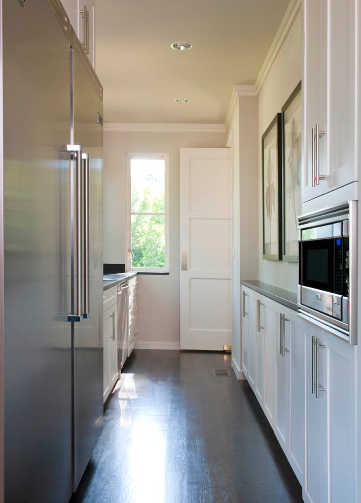 Foto di una cucina design con lavello sottopiano, ante in stile shaker, ante bianche, top in granito e elettrodomestici in acciaio inossidabile