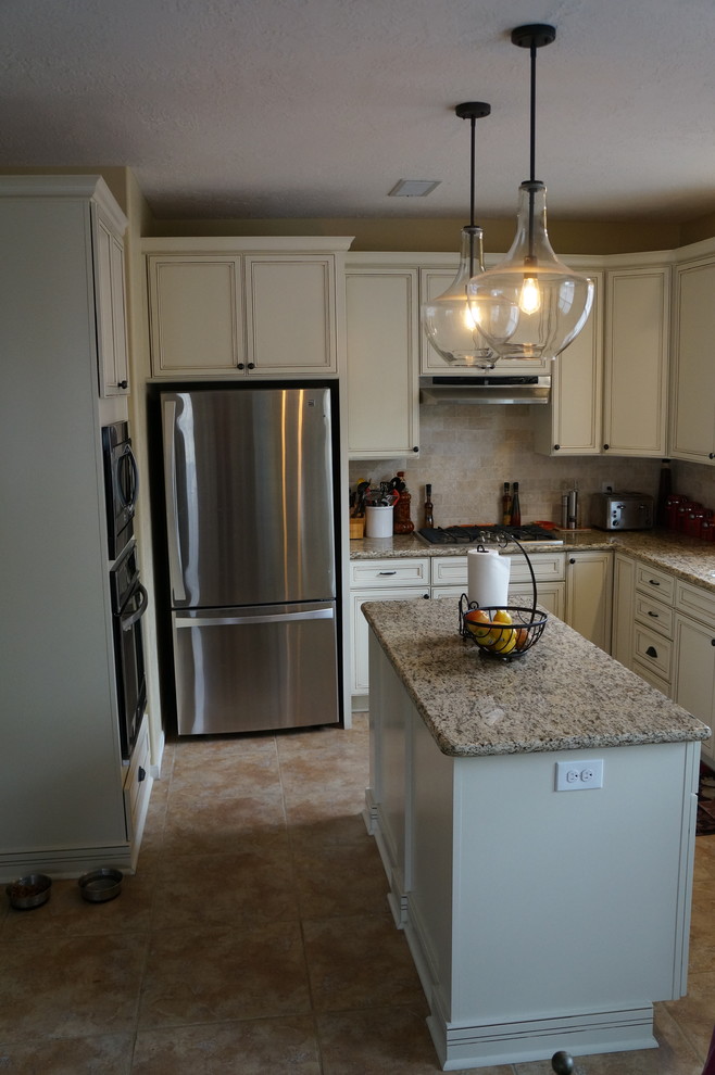 Photo of a classic kitchen in Houston with a submerged sink, flat-panel cabinets, white cabinets, granite worktops, beige splashback, stone tiled splashback, stainless steel appliances and an island.