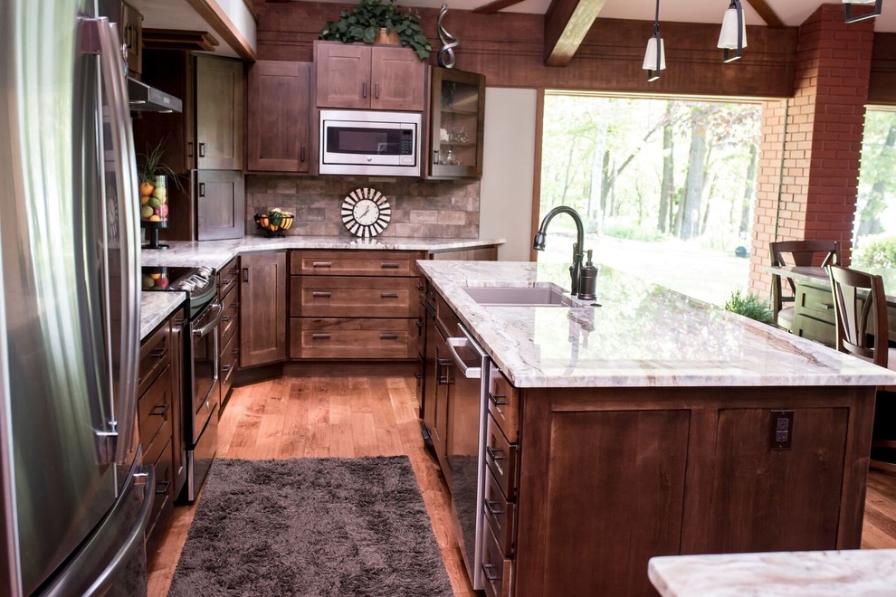 Eat-in kitchen - large craftsman l-shaped medium tone wood floor and brown floor eat-in kitchen idea in Other with an undermount sink, shaker cabinets, brown cabinets, granite countertops, brown backsplash, brick backsplash, stainless steel appliances, two islands and multicolored countertops