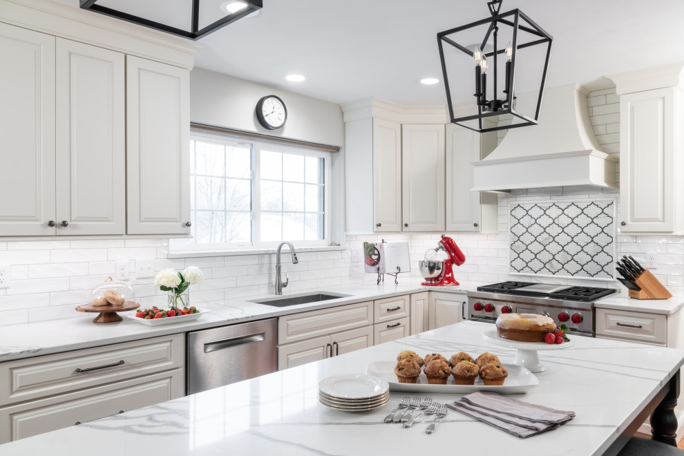 Inspiration for a large traditional kitchen in St Louis with a submerged sink, raised-panel cabinets, white cabinets, engineered stone countertops, white splashback, ceramic splashback, stainless steel appliances, medium hardwood flooring and white worktops.