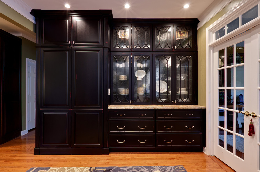 Large elegant single-wall medium tone wood floor and brown floor kitchen pantry photo in Atlanta with raised-panel cabinets, black cabinets, granite countertops and beige countertops