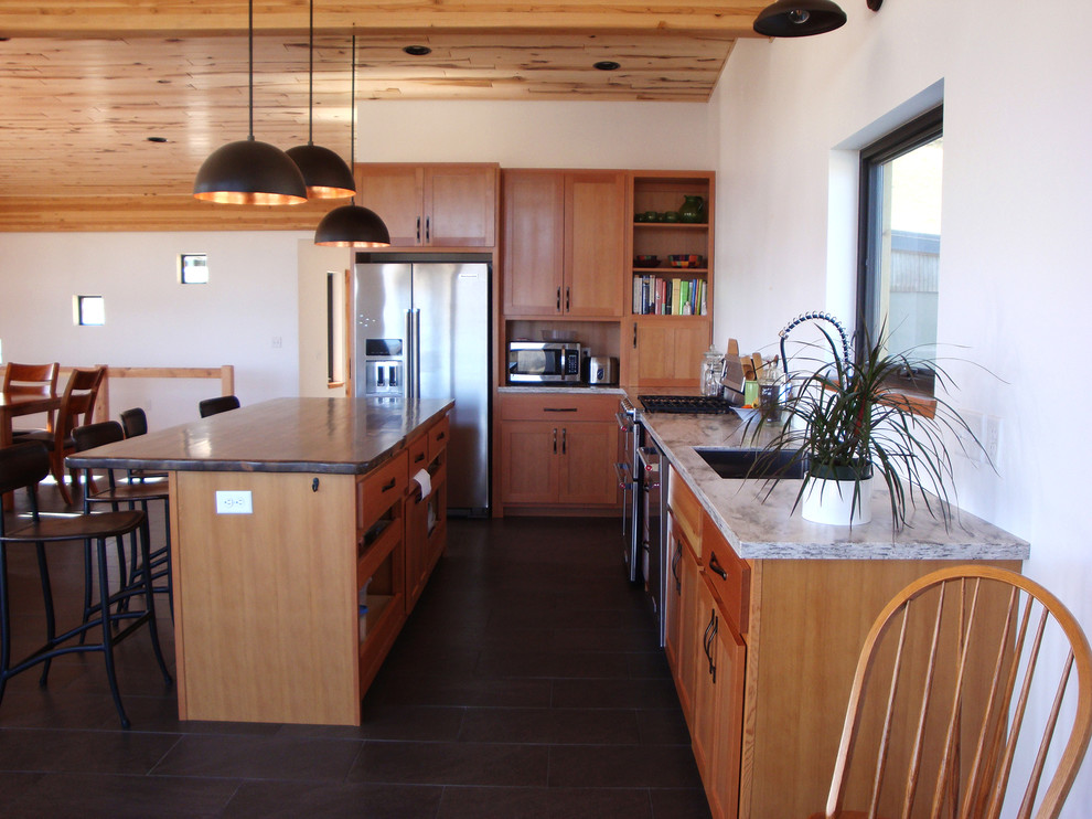 Cette photo montre une cuisine moderne en bois clair avec un évier posé, un placard à porte shaker, un plan de travail en bois, un électroménager en acier inoxydable, un sol en carrelage de céramique et îlot.