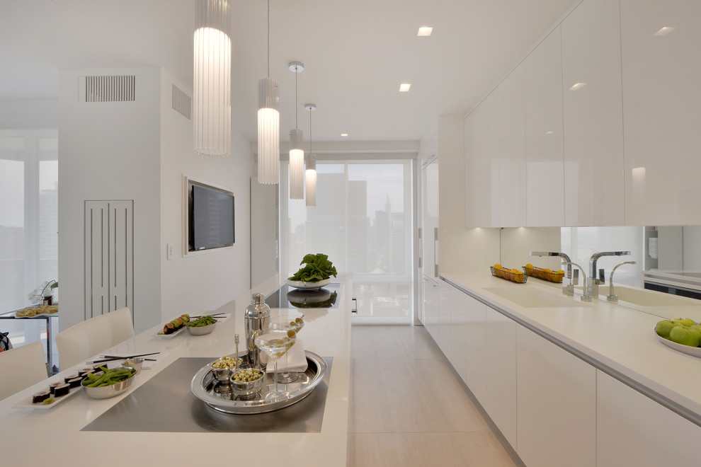 This is an example of a small contemporary l-shaped enclosed kitchen in New York with an integrated sink, flat-panel cabinets, white cabinets, composite countertops, mirror splashback, white appliances, porcelain flooring, an island and beige floors.