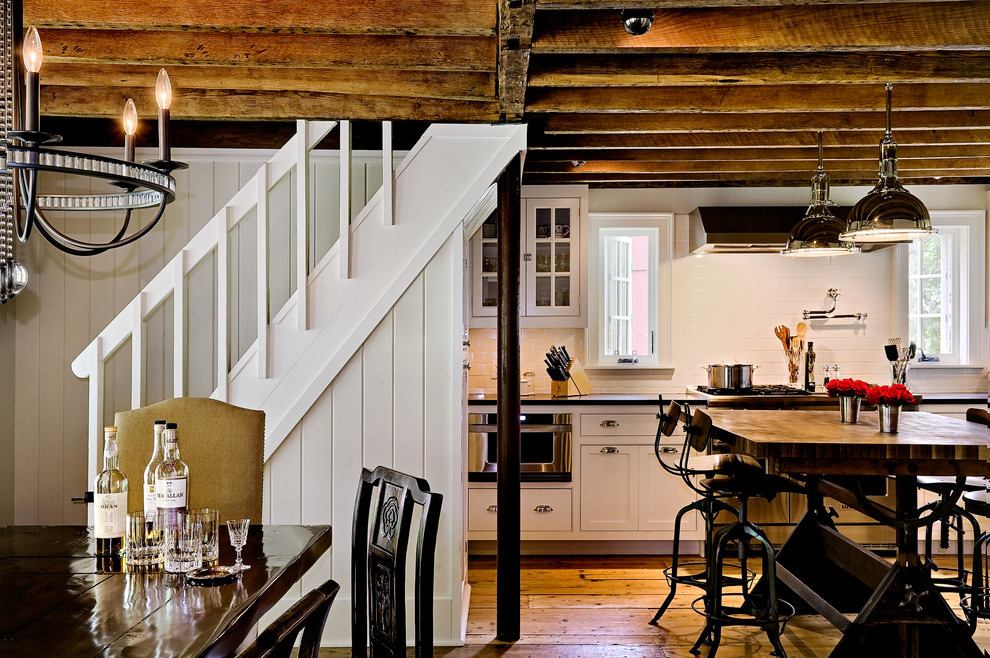 Exempel på ett lantligt kök och matrum, med luckor med profilerade fronter, vita skåp, bänkskiva i täljsten, vitt stänkskydd, stänkskydd i tunnelbanekakel, en rustik diskho och rostfria vitvaror