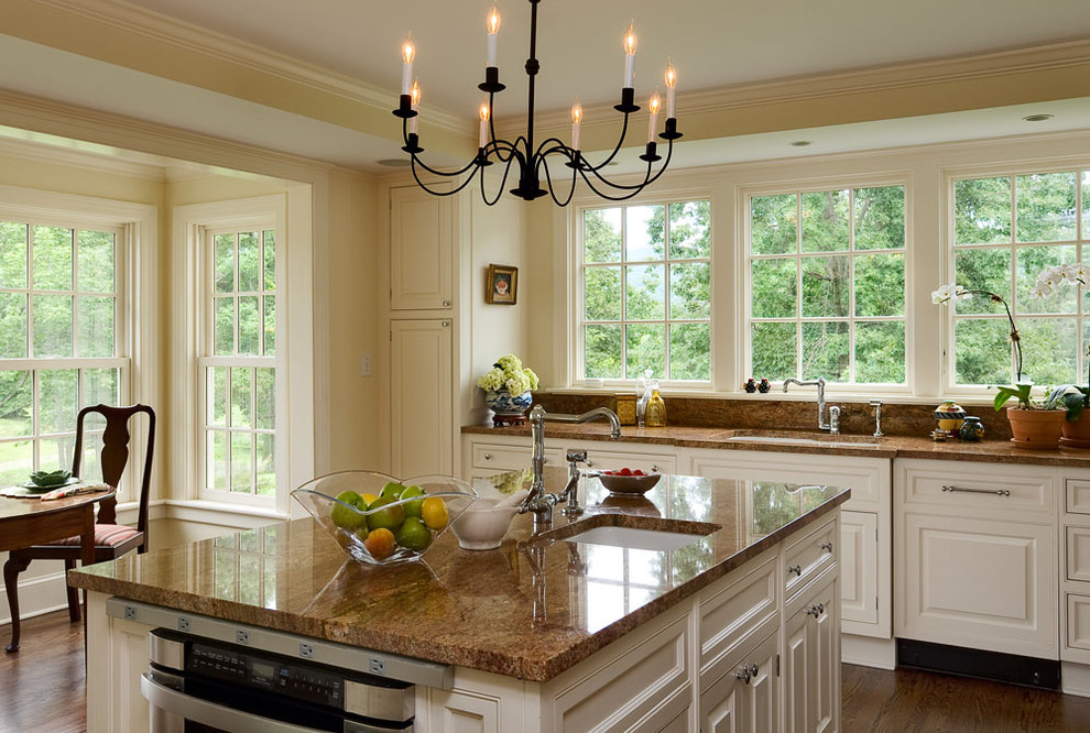 Example of a classic eat-in kitchen design in New York with raised-panel cabinets, white cabinets, granite countertops, an undermount sink and stainless steel appliances