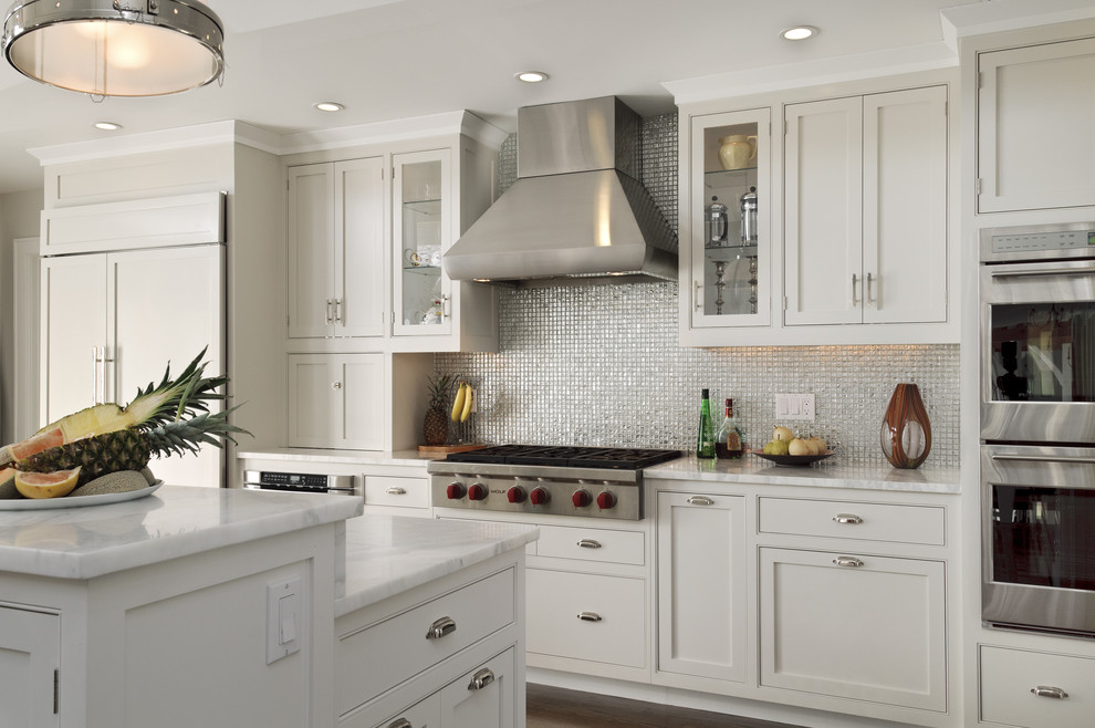 Eat-in kitchen - farmhouse eat-in kitchen idea in New York with mosaic tile backsplash, stainless steel appliances, white cabinets, marble countertops, metallic backsplash, a drop-in sink and beaded inset cabinets