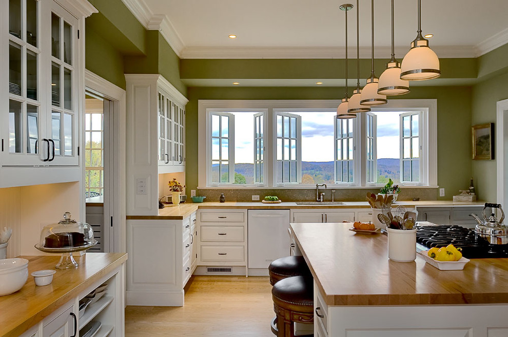 Immagine di una cucina abitabile chic con ante di vetro, ante bianche, top in legno, elettrodomestici bianchi, lavello sottopiano e paraspruzzi bianco