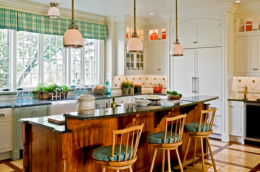 Inspiration for a timeless eat-in kitchen remodel in New York with paneled appliances, a farmhouse sink, white cabinets, granite countertops, multicolored backsplash, recessed-panel cabinets and ceramic backsplash