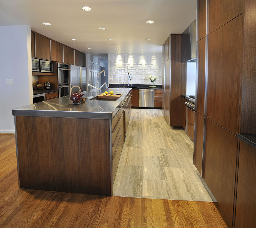 Moderne Wohnküche in U-Form mit Küchengeräten aus Edelstahl, flächenbündigen Schrankfronten, dunklen Holzschränken, Edelstahl-Arbeitsplatte, Küchenrückwand in Weiß und Unterbauwaschbecken in Cincinnati
