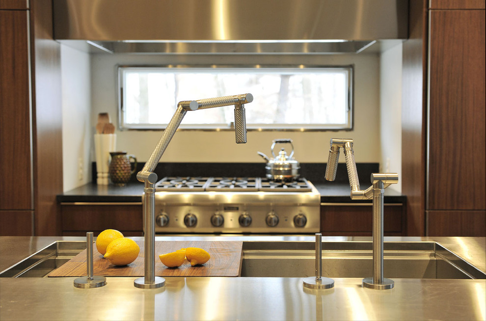 Immagine di una cucina moderna con lavello a vasca singola, ante lisce, ante in legno scuro, top in acciaio inossidabile e elettrodomestici in acciaio inossidabile