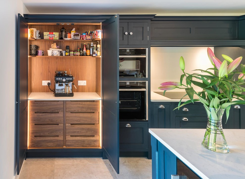 Large contemporary l-shaped open plan kitchen in Kent with recessed-panel cabinets, blue cabinets, quartz worktops, white splashback, an island, white worktops and stainless steel appliances.