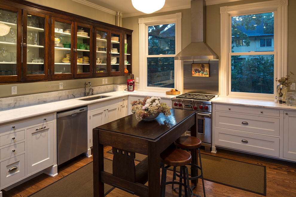 Inspiration for a craftsman l-shaped dark wood floor open concept kitchen remodel in Minneapolis with an undermount sink, recessed-panel cabinets, dark wood cabinets, marble countertops, gray backsplash, stone slab backsplash and stainless steel appliances