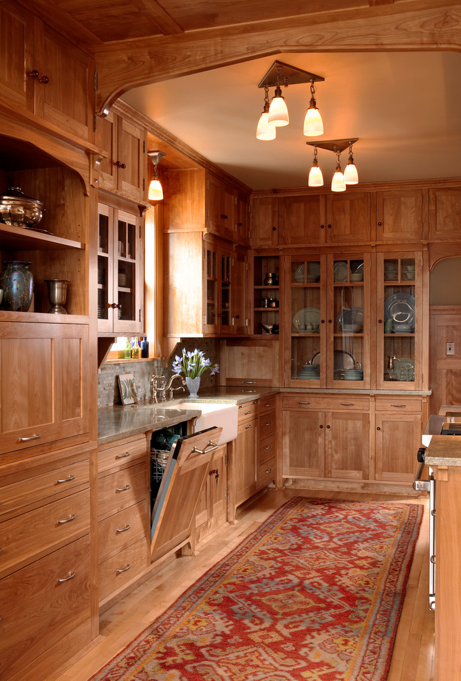 Inspiration for a craftsman galley medium tone wood floor eat-in kitchen remodel in Minneapolis with a farmhouse sink, medium tone wood cabinets, recessed-panel cabinets, paneled appliances, gray backsplash, no island, granite countertops and stone tile backsplash