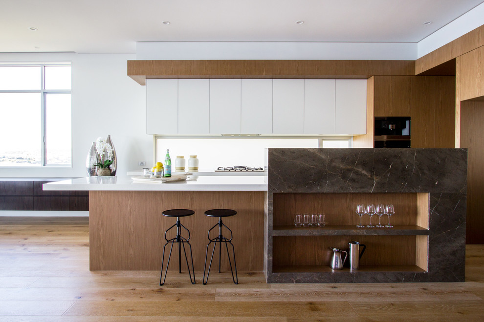 Diseño de cocina actual con armarios con paneles lisos, suelo de madera en tonos medios, una isla, puertas de armario de madera oscura y salpicadero de vidrio