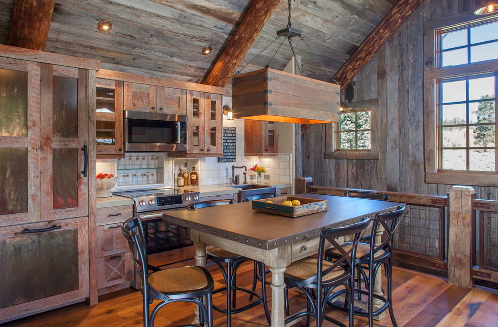 Eat-in kitchen - rustic single-wall medium tone wood floor eat-in kitchen idea in Denver with a farmhouse sink, shaker cabinets, distressed cabinets, white backsplash, subway tile backsplash and no island
