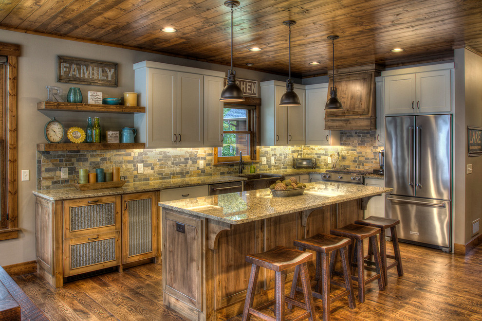 This is an example of a rustic l-shaped kitchen in Minneapolis with a belfast sink, shaker cabinets, grey cabinets, multi-coloured splashback, stainless steel appliances, dark hardwood flooring, an island, brown floors and brown worktops.
