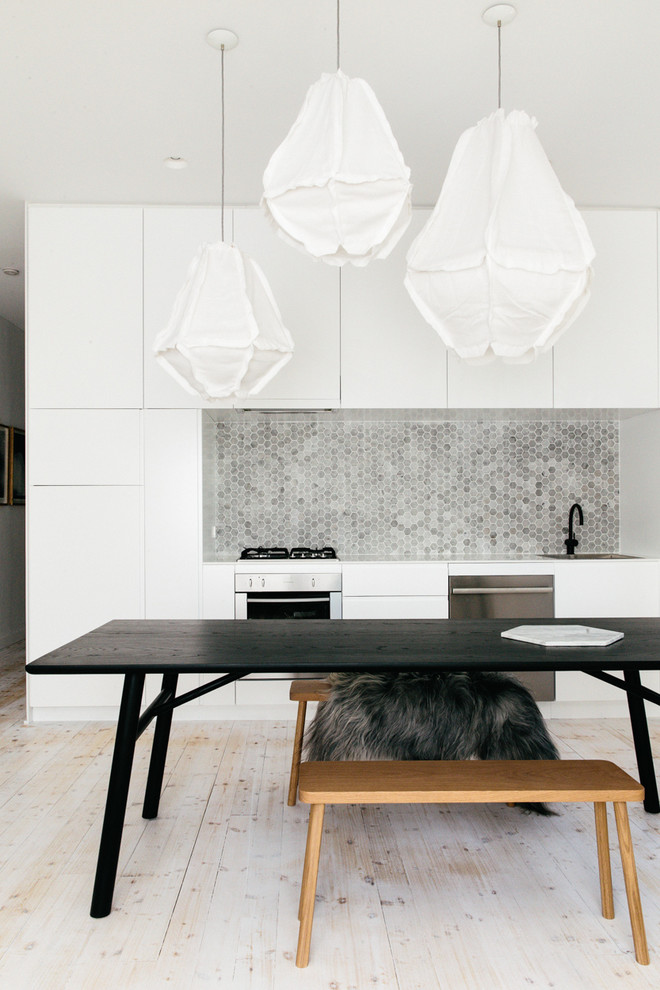 Einzeilige Skandinavische Wohnküche mit Küchenrückwand in Grau, Rückwand aus Steinfliesen, Küchengeräten aus Edelstahl, flächenbündigen Schrankfronten, weißen Schränken und hellem Holzboden in Sydney