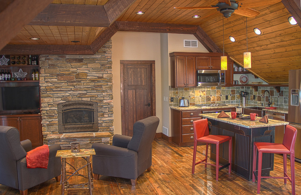 Urige Küche mit Landhausspüle, profilierten Schrankfronten, braunen Schränken, Granit-Arbeitsplatte, bunter Rückwand, Rückwand aus Schiefer, Küchengeräten aus Edelstahl, braunem Holzboden, Kücheninsel und braunem Boden in Minneapolis