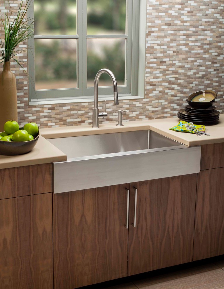 This is an example of a modern kitchen with a belfast sink, medium wood cabinets, brown splashback and beige worktops.