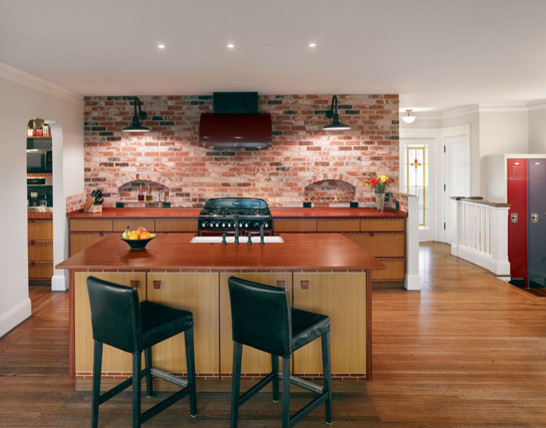 Large elegant dark wood floor open concept kitchen photo in San Francisco with flat-panel cabinets, light wood cabinets, wood countertops, black appliances, an island and a farmhouse sink