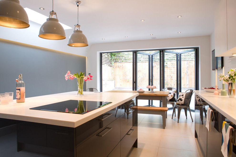This is an example of a medium sized contemporary single-wall kitchen/diner in Kent with flat-panel cabinets, grey cabinets, white splashback, an island and white floors.