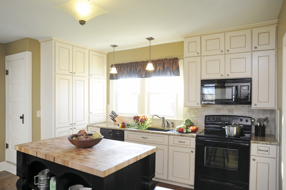 Mid-sized farmhouse l-shaped medium tone wood floor and brown floor eat-in kitchen photo in Other with an undermount sink, beaded inset cabinets, white cabinets, granite countertops, white backsplash, ceramic backsplash, black appliances and an island