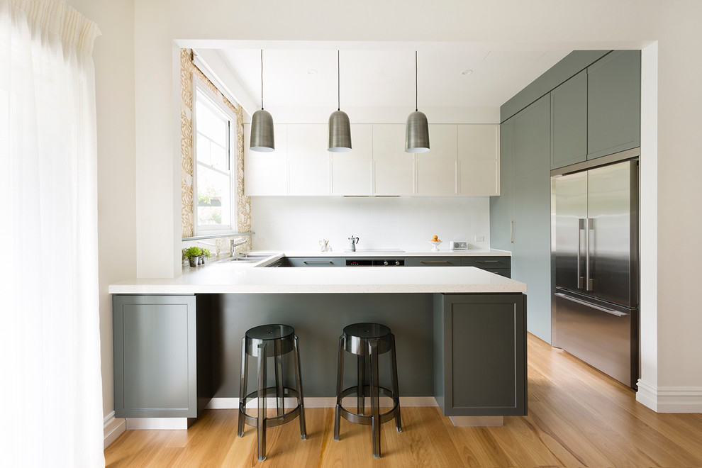 Kitchen - mid-sized transitional u-shaped medium tone wood floor kitchen idea in Melbourne with a double-bowl sink, recessed-panel cabinets, gray cabinets, quartz countertops, white backsplash, subway tile backsplash and stainless steel appliances