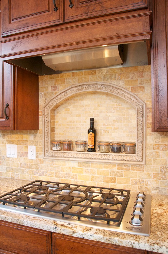 Inredning av ett klassiskt mellanstort u-kök, med en rustik diskho, luckor med upphöjd panel, skåp i mellenmörkt trä, granitbänkskiva, beige stänkskydd, stänkskydd i stenkakel, rostfria vitvaror, en köksö och travertin golv