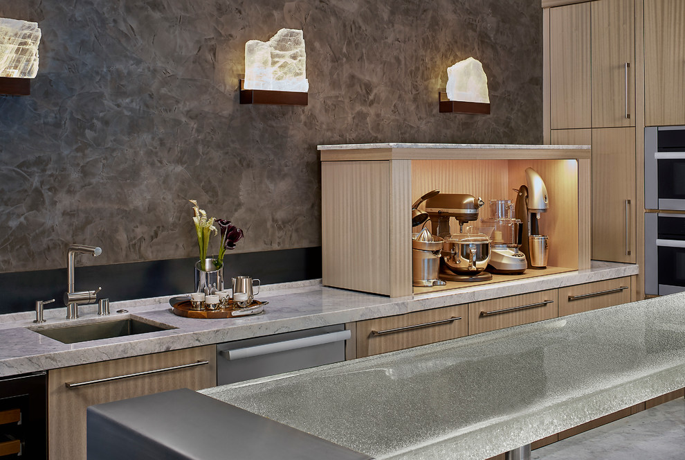 Foto di una grande cucina minimal chiusa con lavello sottopiano, ante lisce, ante in legno chiaro, top in granito, paraspruzzi grigio, paraspruzzi con lastra di vetro e elettrodomestici in acciaio inossidabile