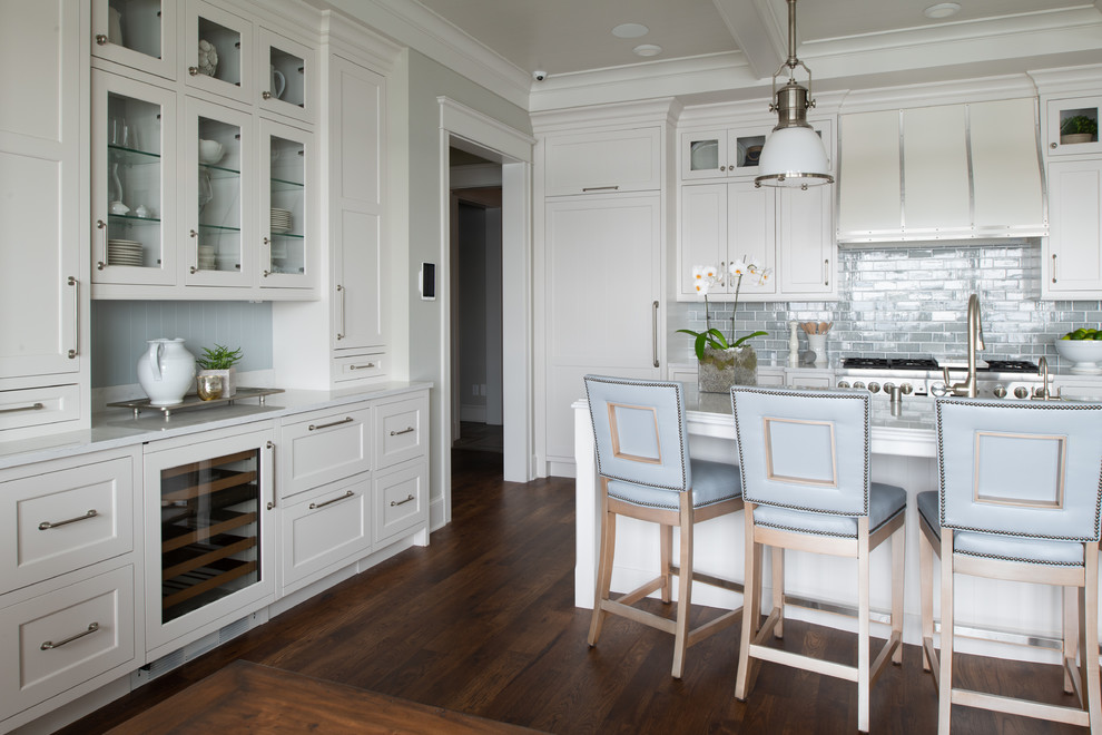Inspiration for a mid-sized country single-wall dark wood floor and brown floor eat-in kitchen remodel in Minneapolis with a farmhouse sink, shaker cabinets, white cabinets, marble countertops, blue backsplash, subway tile backsplash, paneled appliances, an island and white countertops