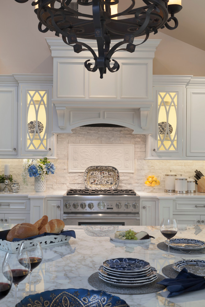 Eat-in kitchen - large transitional u-shaped ceramic tile eat-in kitchen idea in New York with a single-bowl sink, beaded inset cabinets, white cabinets, marble countertops, white backsplash, stone tile backsplash, stainless steel appliances and an island