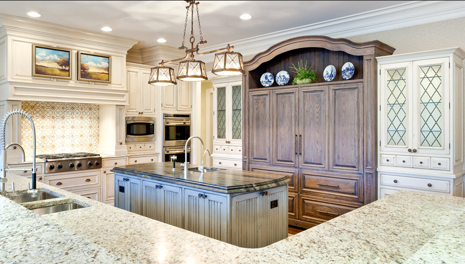 Kitchen - mid-sized traditional u-shaped kitchen idea in Chicago with a double-bowl sink, raised-panel cabinets, white cabinets, granite countertops, stainless steel appliances and an island