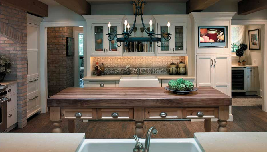 Photo of a medium sized rustic u-shaped enclosed kitchen in Chicago with a belfast sink, shaker cabinets, beige cabinets, stainless steel appliances, dark hardwood flooring and an island.