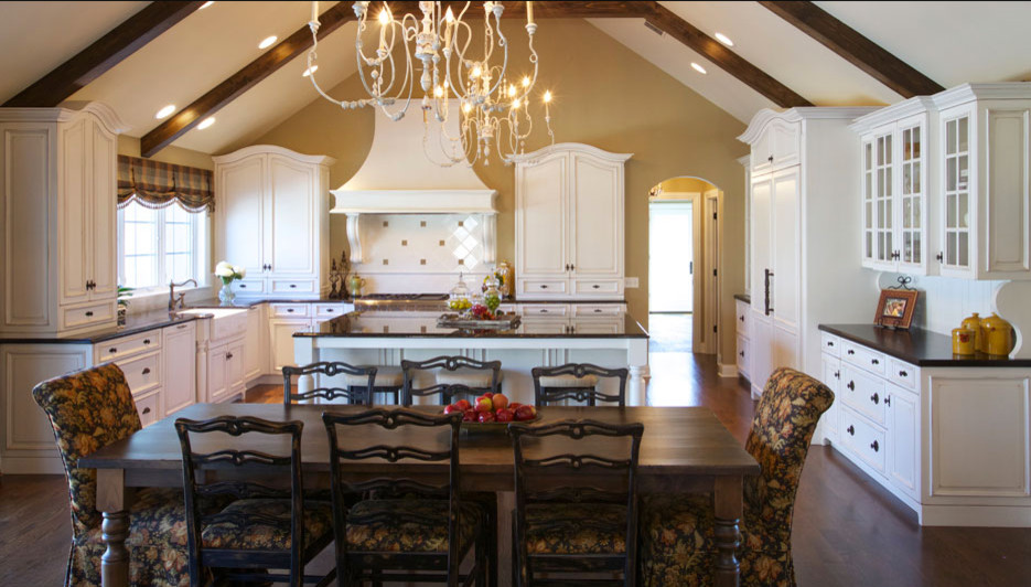 Example of a mid-sized classic u-shaped dark wood floor eat-in kitchen design in Chicago with a farmhouse sink, recessed-panel cabinets, white cabinets, paneled appliances and an island